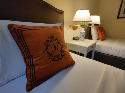 a bed with a brown pillow on top of it at Grand Regal Hotel Davao in Davao City