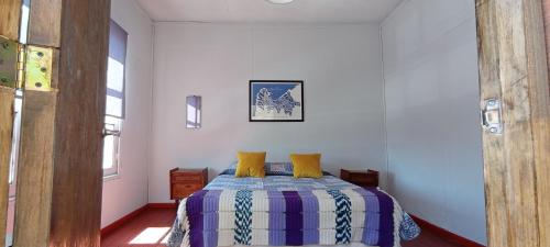 a bedroom with a bed with yellow pillows on it at Selva Hospedaje in Valparaíso