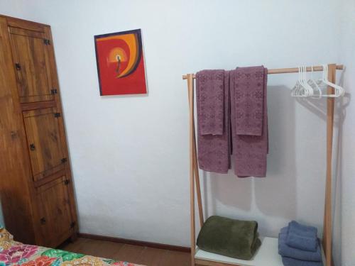 ein Schlafzimmer mit lila Handtüchern an der Wand in der Unterkunft Secret Recreio in Rio de Janeiro