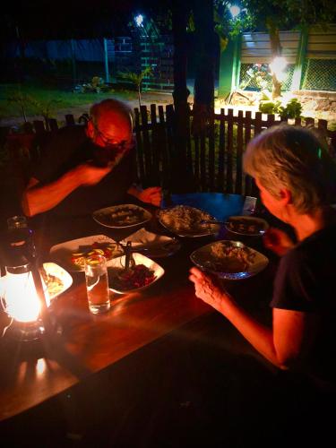 a man and woman sitting at a table with plates of food at Wilpattu Green Cabin in Achchamulai