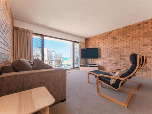 a living room with a couch and a chair at San Clemente 3 24 Orvieto Tce in Caloundra