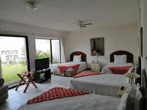 um quarto de hotel com duas camas e uma televisão em Novohostal B&B em Guatemala