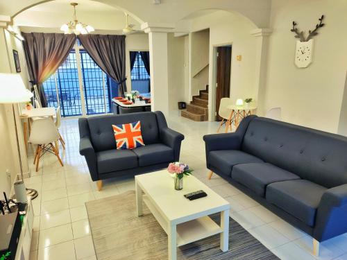 uma sala de estar com dois sofás azuis e uma mesa em Semi-Detached, Up to 21 Pax, 4 Bedrooms, 3 Bathrooms, 4 Car Parks em Bayan Lepas