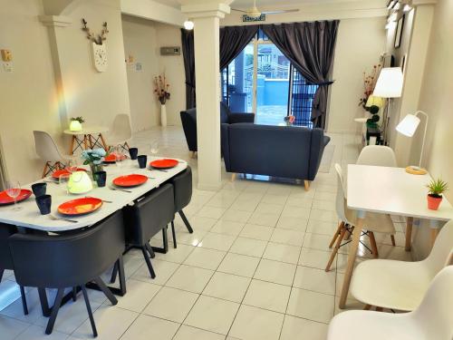 uma sala de jantar e sala de estar com mesa e cadeiras em Semi-Detached, Up to 21 Pax, 4 Bedrooms, 3 Bathrooms, 4 Car Parks em Bayan Lepas