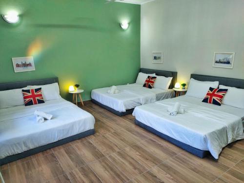 a room with two beds and a green wall at Semi-Detached, Up to 21 Pax, 4 Bedrooms, 3 Bathrooms, 4 Car Parks by Star Home in Bayan Lepas