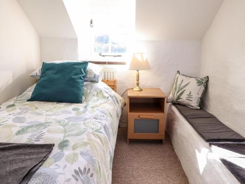 a small bedroom with a bed and a night stand at Middle Cottage in Newport Pembrokeshire