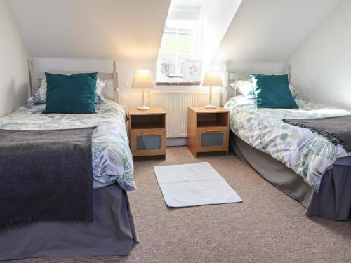 ein Schlafzimmer mit zwei Betten und zwei Nachttischen in der Unterkunft End Cottage in Newport