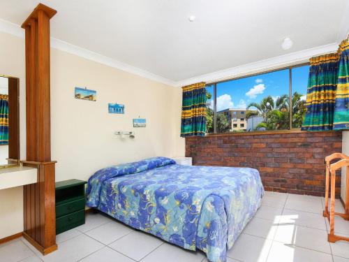 a bedroom with a bed and a large window at Sha na na Unit 3 Kings Beach Gem in Caloundra