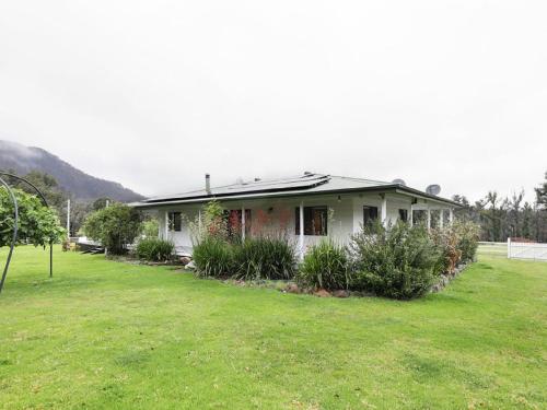 a small white house with a grass yard at The Hamilton Kangaroo Valley in Kangaroo Valley