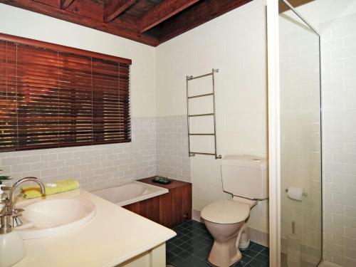 a bathroom with a toilet and a sink and a tub at Sweet Gum Bend Delightful 2 bedroom cottage in Kangaroo Valley