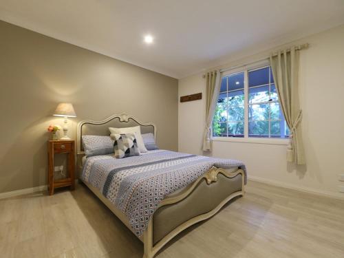 a bedroom with a bed and a window at Peaceful Bushland Retreat in Kangaroo Valley
