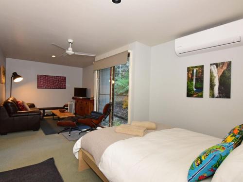 Upper Kangaroo RiverにあるBudderoo Unique with 270 degree viewsのベッドルーム1室(ベッド1台付)、リビングルームが備わります。
