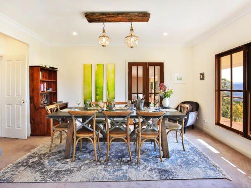 a dining room with a table and chairs at Wild Peace Mountain Lodge Kangaroo Valley in Bellawongarah