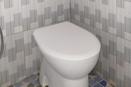 a bathroom with a white toilet in a room at Habieb Homestay Syariah near Fakultas Kedokteran Universitas Malikussaleh Mitra RedDoorz in Kadang
