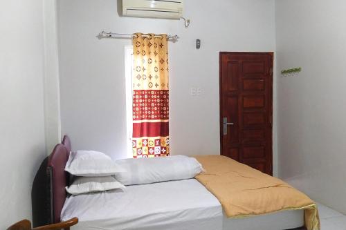 a small bedroom with a bed and a window at Habieb Homestay Syariah near Fakultas Kedokteran Universitas Malikussaleh Mitra RedDoorz in Kadang