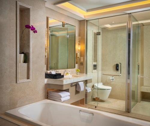 a bathroom with a tub and a sink and a toilet at InterContinental Hotels Jakarta Pondok Indah by IHG in Jakarta