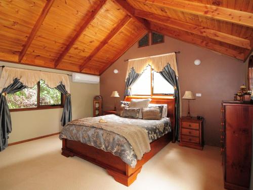 1 dormitorio con cama y techo de madera en Orange Blossom Retreat, en Valle Kangaroo
