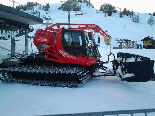 a snow bulldozer parked next to a ski lift at Alpenrose Nassfeld in Sonnenalpe Nassfeld