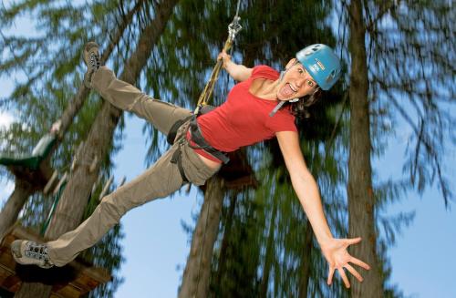 a woman is hanging on a rope swing at Alpenrose Nassfeld in Sonnenalpe Nassfeld