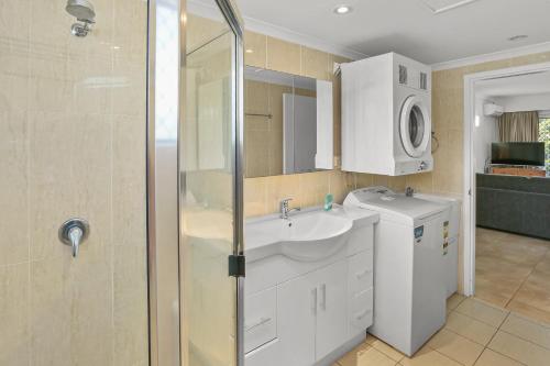 a bathroom with a sink and a shower at Agincourt Beachfront Apartments in Clifton Beach