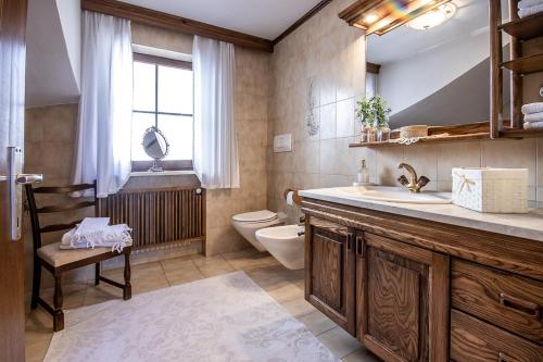 a bathroom with a sink and a toilet and a window at Ferienhaus Winkler in Anterivo