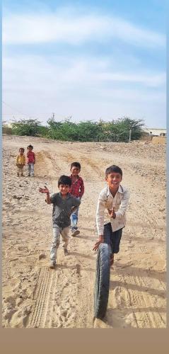 a group of children playing with a tire on the beach at Marigold Home Stay in Jaisalmer