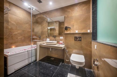 een badkamer met een wastafel, een toilet en een bad bij Lords Inn Chandigarh Zirakpur in Zirakpur