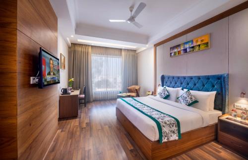 a bedroom with a large bed with a blue headboard at Lords Inn Chandigarh Zirakpur in Zirakpur