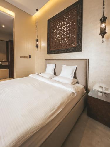a bedroom with a large bed with white sheets at Riad Dar Al Rumman in Qurayyah