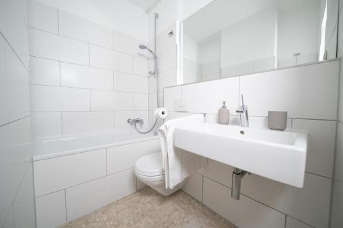 uma casa de banho branca com um WC e um lavatório em Apartment Blue - Zentral und gut angebunden em Dusseldorf