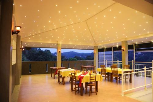 een restaurant met tafels en stoelen en verlichting aan het plafond bij Crown & Crown Kandy in Kandy