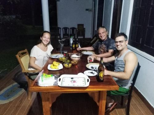 a group of people sitting around a wooden table at Deer Garden Guest in Polonnaruwa