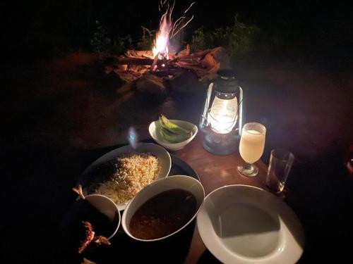 a table with two bowls of food and a fire at Trekkers' Hut Knuckles in Kaduwela