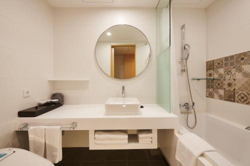 a white bathroom with a sink and a mirror at Nine Tree by Parnas Seoul Insadong in Seoul