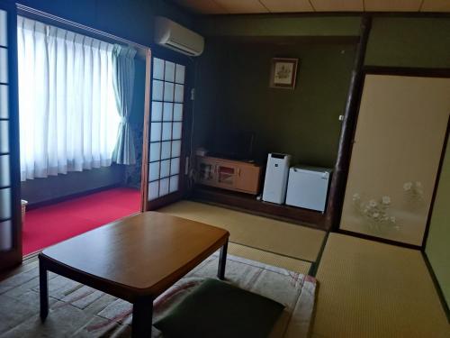 Iizukaあけぼの館的带桌子和窗户的客厅