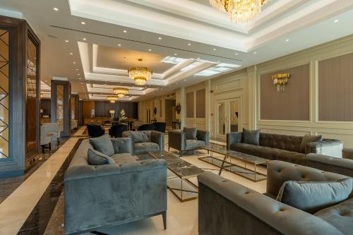 a lobby with couches and tables in a building at Astoria Grand Hotel in Sofia