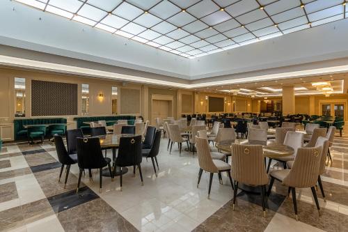 a restaurant with tables and chairs in a room at Astoria Grand Hotel in Sofia