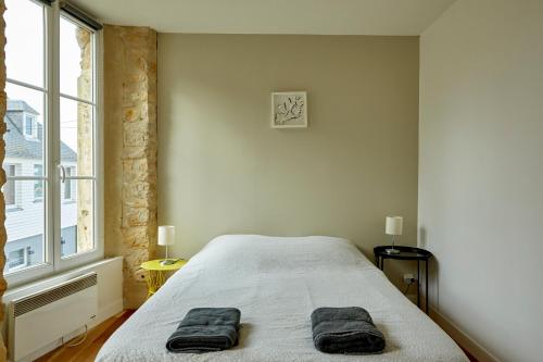 Un dormitorio con una cama con dos toallas encima. en Appartement front mer proche omaha & utah beach - 1, en Grandcamp-Maisy