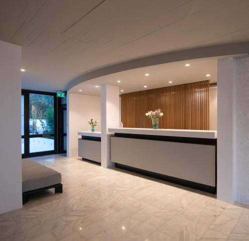 a lobby with a reception desk and flowers on the wall at Apollo Resort in Agia Marina Aegina