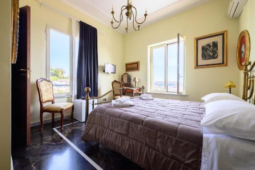 a bedroom with a bed and a chair and windows at Villa Emilia in Pozzuoli