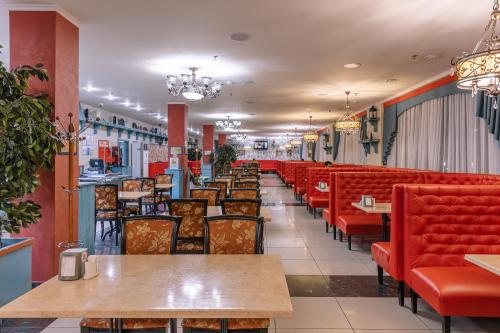 エッセントゥキにあるБизнес-отель "Эринии"の赤い椅子とテーブル付きのダイニングルーム