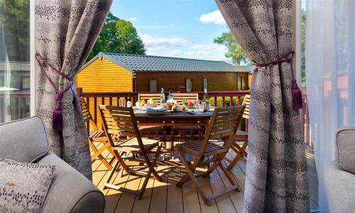 a wooden deck with a table and chairs on a balcony at Lancashire Rose in Windermere