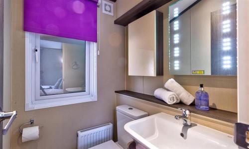 uma casa de banho com um lavatório, um espelho e um WC. em Lancashire Rose em Windermere