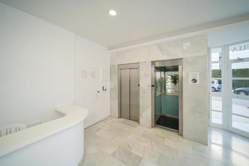 Großes weißes Zimmer mit einem Flur mit Glastür in der Unterkunft Costa Bella in Altea