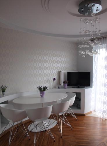 une salle à manger avec une table et des chaises blanches dans l'établissement Apartament Lawendowy, à Jastrzębia Góra