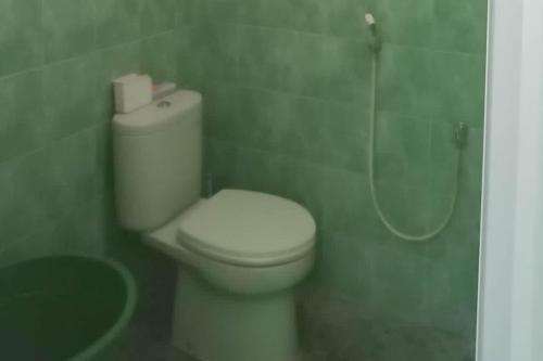 y baño con aseo blanco y ducha. en TRIYOGA Homestay Syariah RedPartner, en Sangkanurip