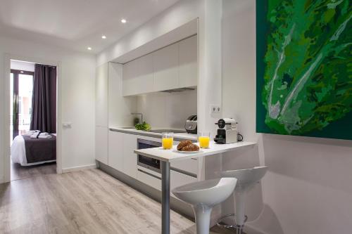 a kitchen with a counter with two glasses of orange juice at Habitat Apartments ADN in Barcelona