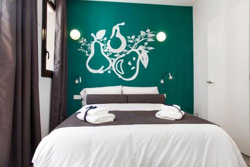 a bedroom with a bed with a green wall at Habitat Apartments ADN in Barcelona