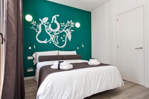 a bedroom with a bed with a green wall at Habitat Apartments ADN in Barcelona