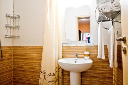 a bathroom with a sink and a toilet and a mirror at Sunflower Apartment City Center in Plovdiv